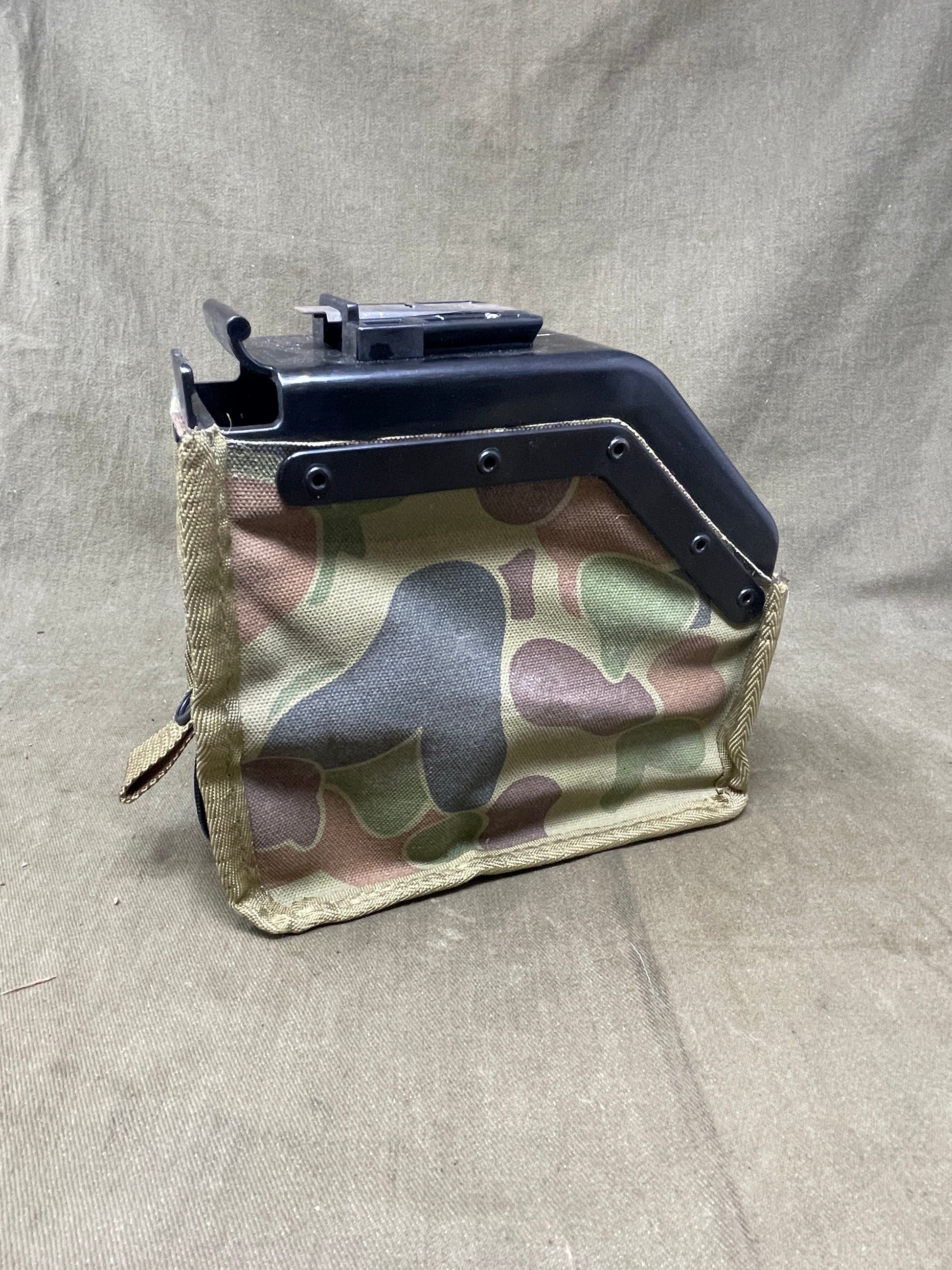 Australian Army LMG pouch, featuring the iconic Australian pattern camouflage. This pouch is designed for durability and functionality, constructed from rugged, heavy-duty materials capable of withstanding harsh field conditions. Its distinctive camouflage pattern ensures effective concealment across a variety of Australian terrains, including dense bushland and arid environments.