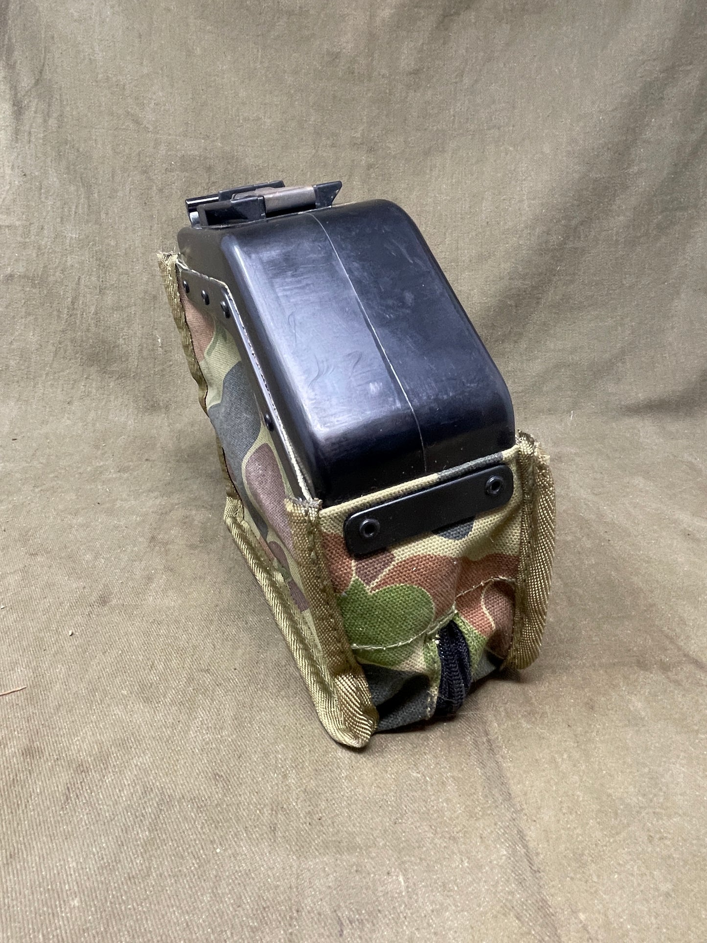 Australian Army LMG pouch, featuring the iconic Australian pattern camouflage. This pouch is designed for durability and functionality, constructed from rugged, heavy-duty materials capable of withstanding harsh field conditions. Its distinctive camouflage pattern ensures effective concealment across a variety of Australian terrains, including dense bushland and arid environments.