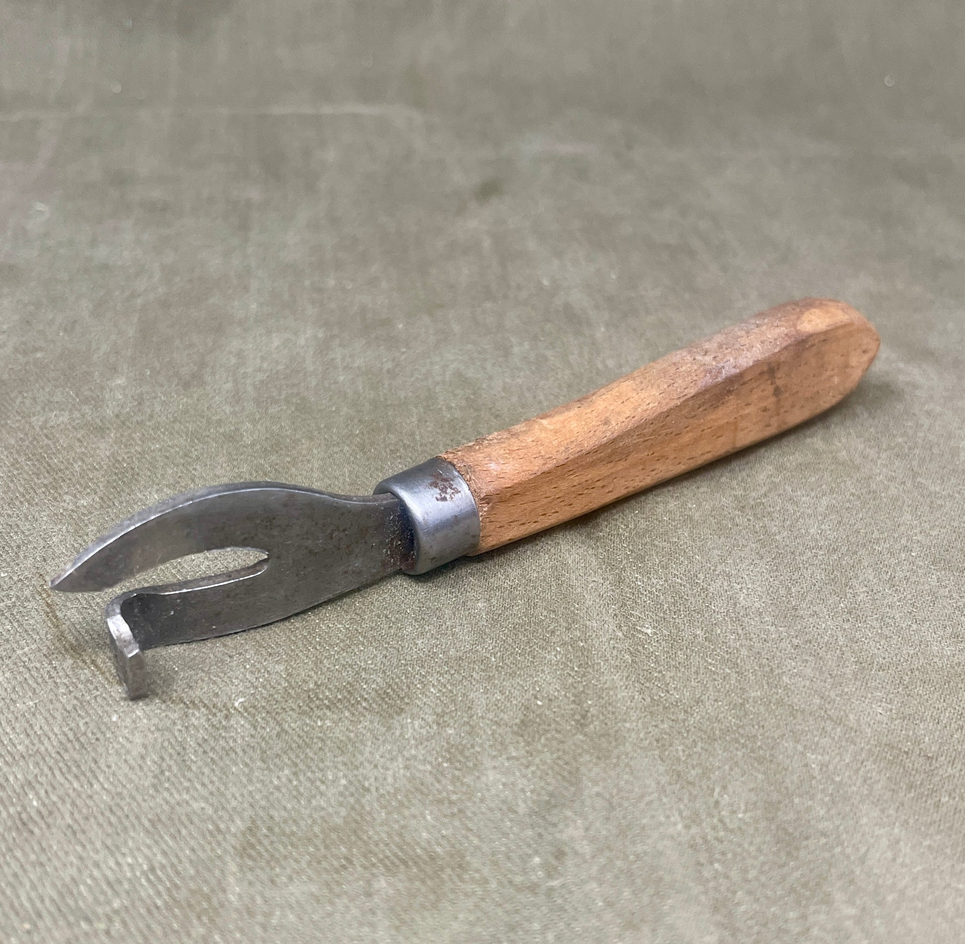 Authentic WWII German Wehrmacht can opener with original wood handle. A rare and practical piece of wartime field equipment for collectors and historians.

