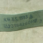 Close-up of a green fabric strip with visible texture on a beige surface