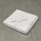 White textured wallet with 'Negretti & Zambra' branding on a gray surface