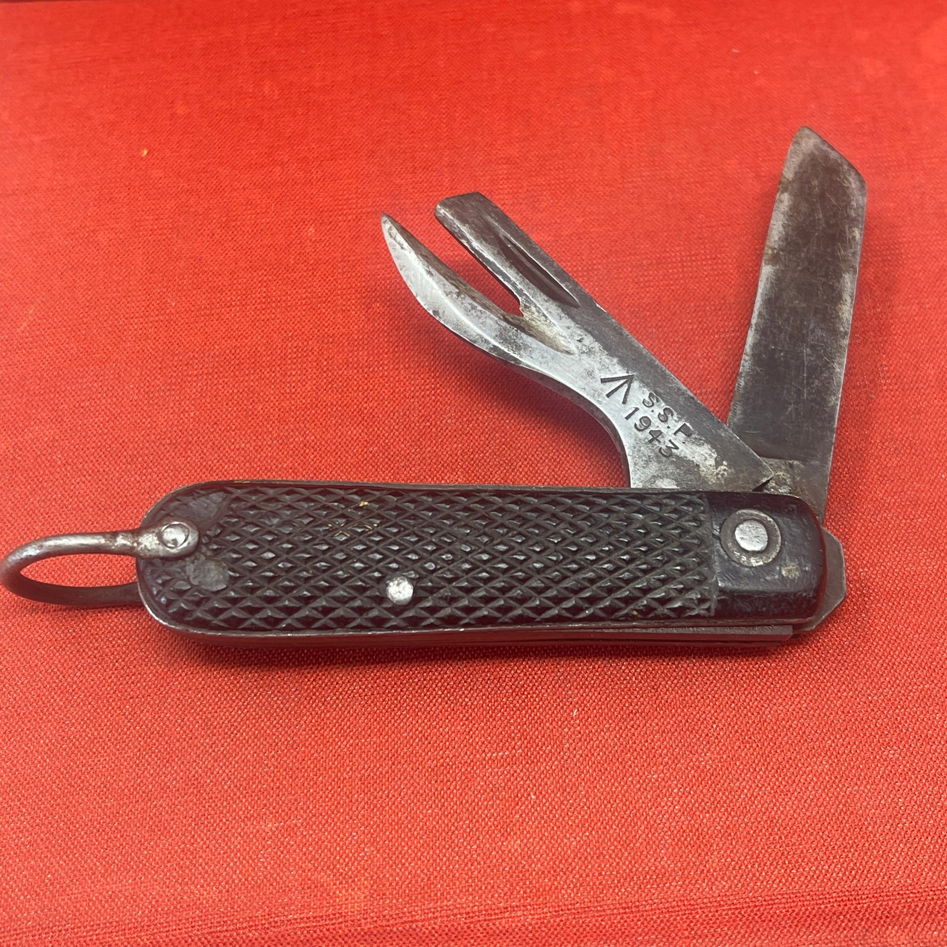 A nice example of a British 1943 Dated Pocket Jack Knife Made by SSP The blades are in good condition, the chequered Bakelite grip is intact ( There is a small piece missing to the left side ) and all the blades lock and close as they should. The steel can opener is in good condition