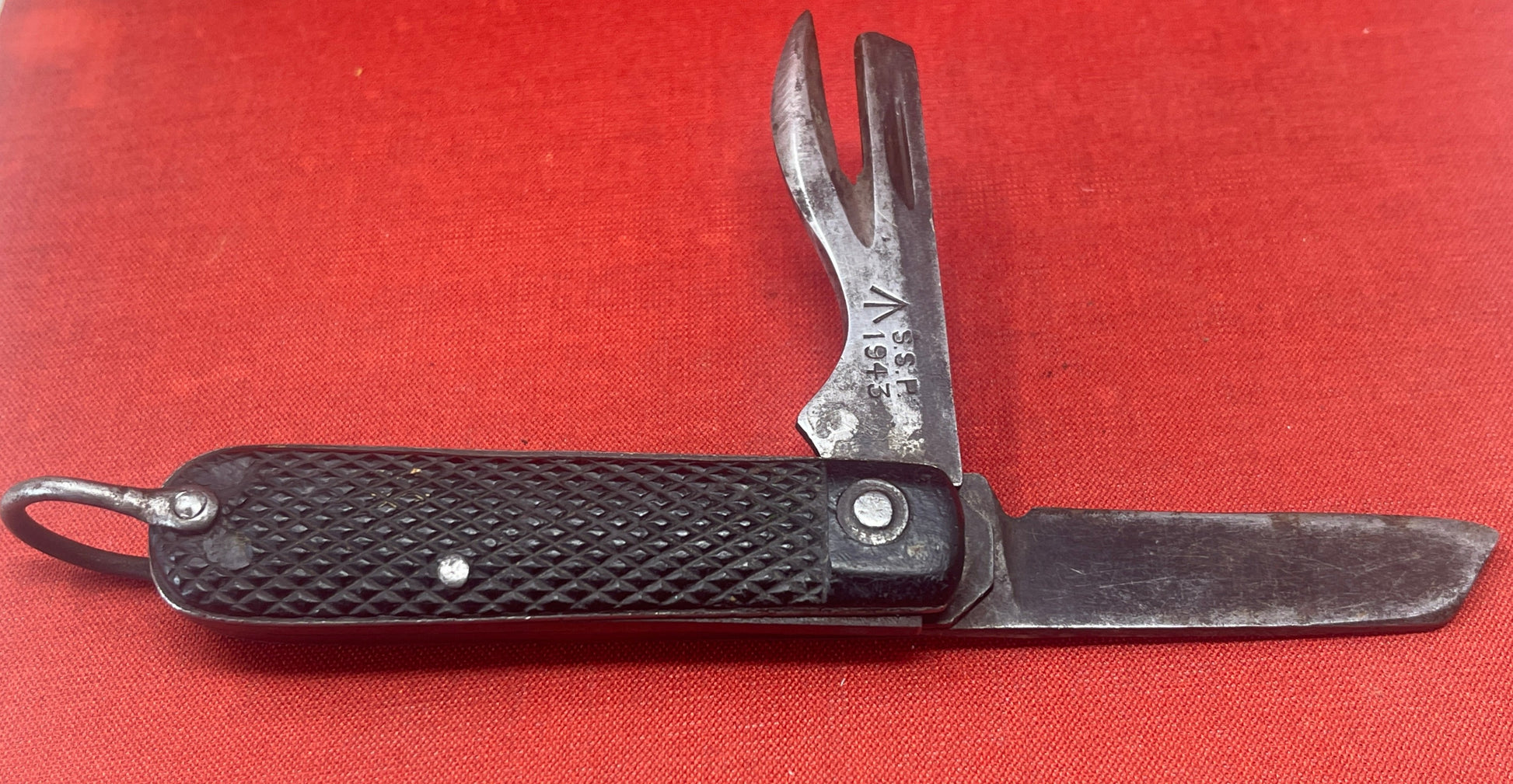 A nice example of a British 1943 Dated Pocket Jack Knife Made by SSP The blades are in good condition, the chequered Bakelite grip is intact ( There is a small piece missing to the left side ) and all the blades lock and close as they should. The steel can opener is in good condition