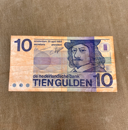 This selection of vintage Dutch Guilder banknotes from the 1960s and 1970s includes denominations of 5, 10, and 25 Gulden, each showcasing distinctive Dutch design and cultural heritage. Issued by De Nederlandsche Bank, these notes feature iconic imagery such as the statue of Erasmus (ƒ5), Baruch Spinoza (ƒ10), and Michiel de Ruyter (ƒ25), reflecting the country’s historical and intellectual legacy. Printed in bold colours and artistic styles, these notes are no longer in circulation, having been replaced b