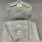 Close-up of a gray fabric pocket with buttons on a dark background