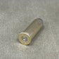 Metallic shotgun shell on a gray surface