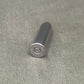 Black cylindrical object with metallic cap on a gray concrete surface