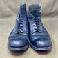 Pair of worn blue boots on a beige fabric background