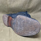 Dark blue leather shoe sole on a beige fabric background