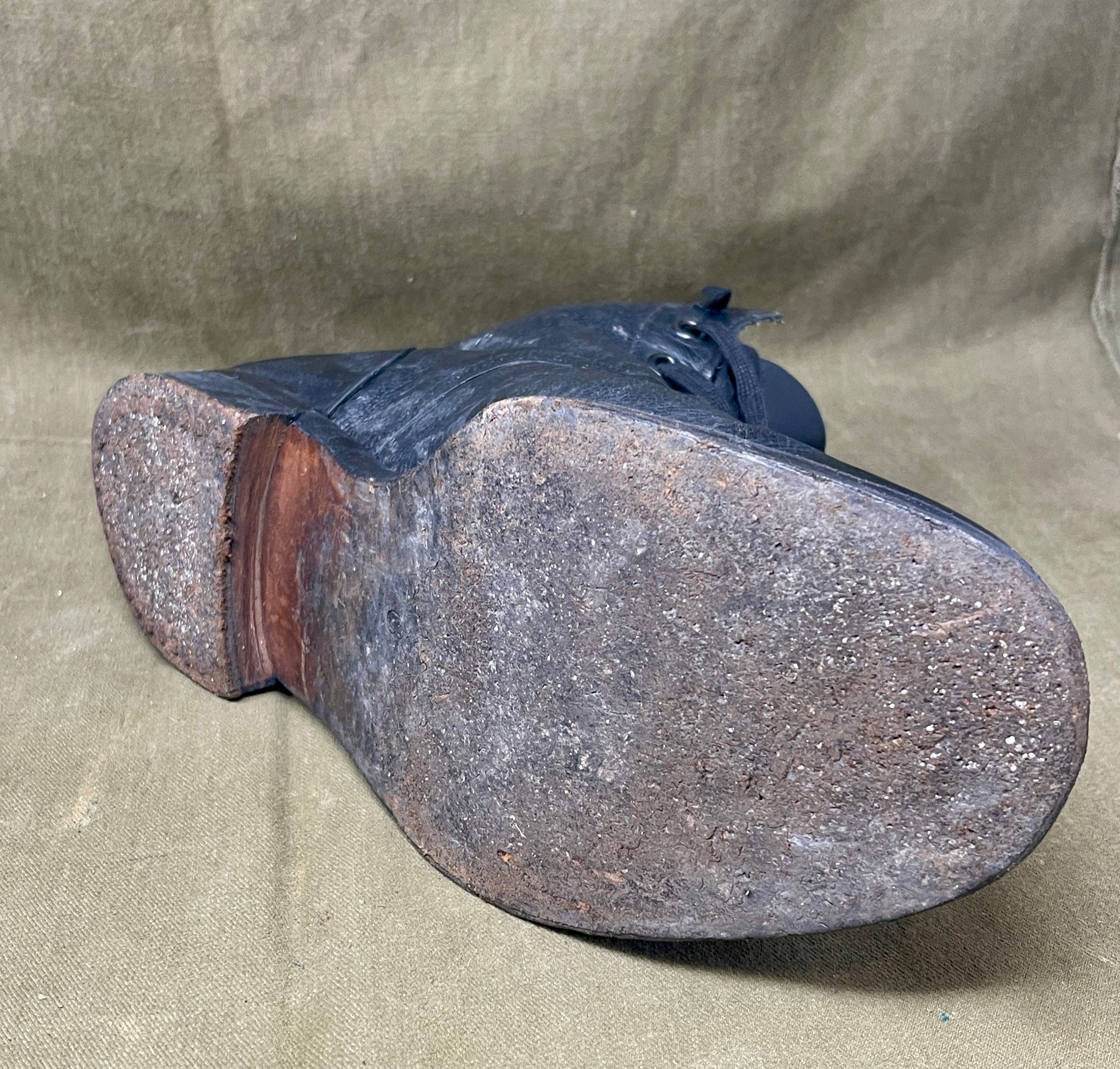 Dark blue leather shoe sole on a beige fabric background