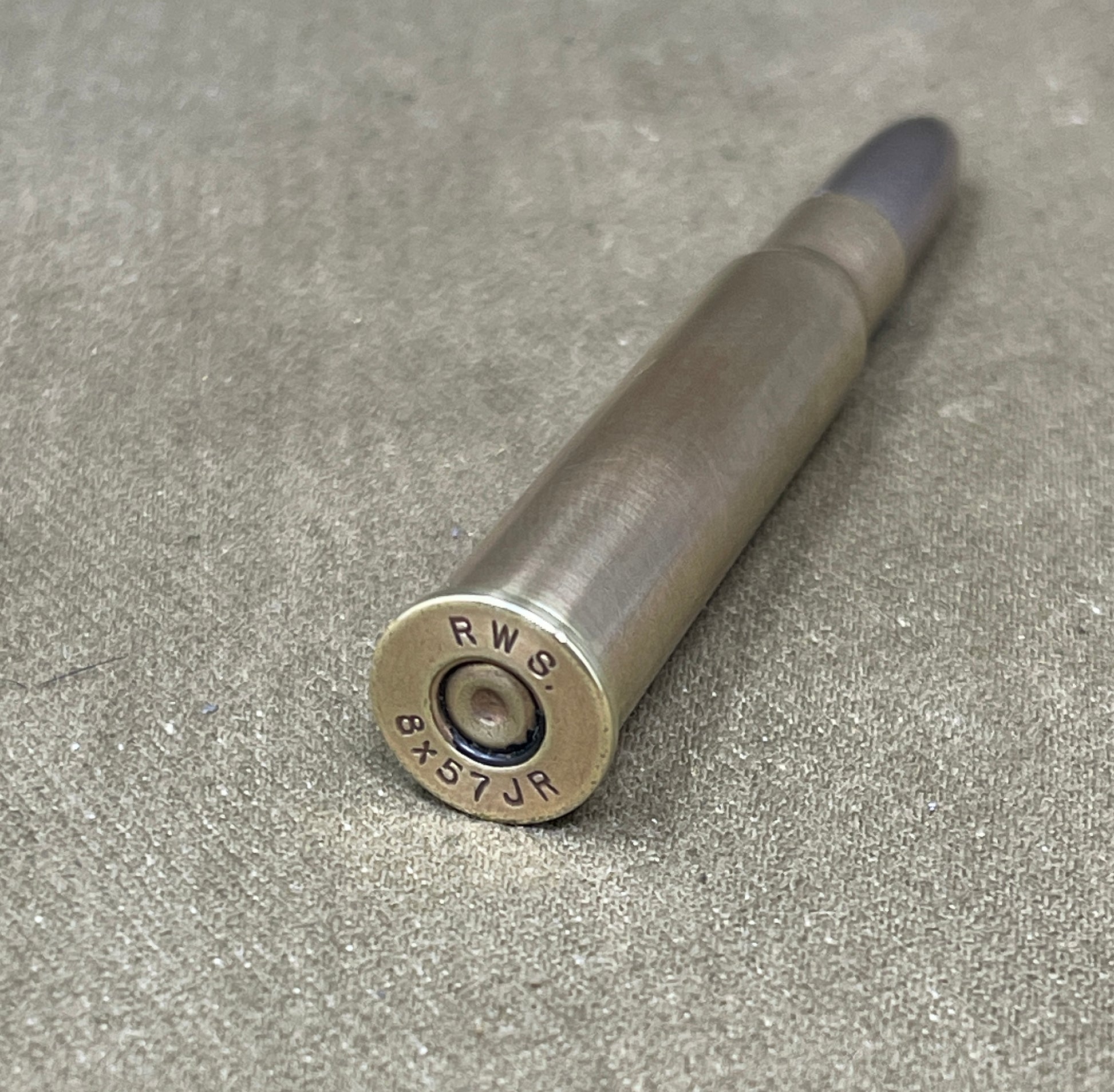 Metallic cylindrical object with 'RWS' branding on a gray surface