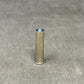 Metallic cylindrical object on a gray concrete surface