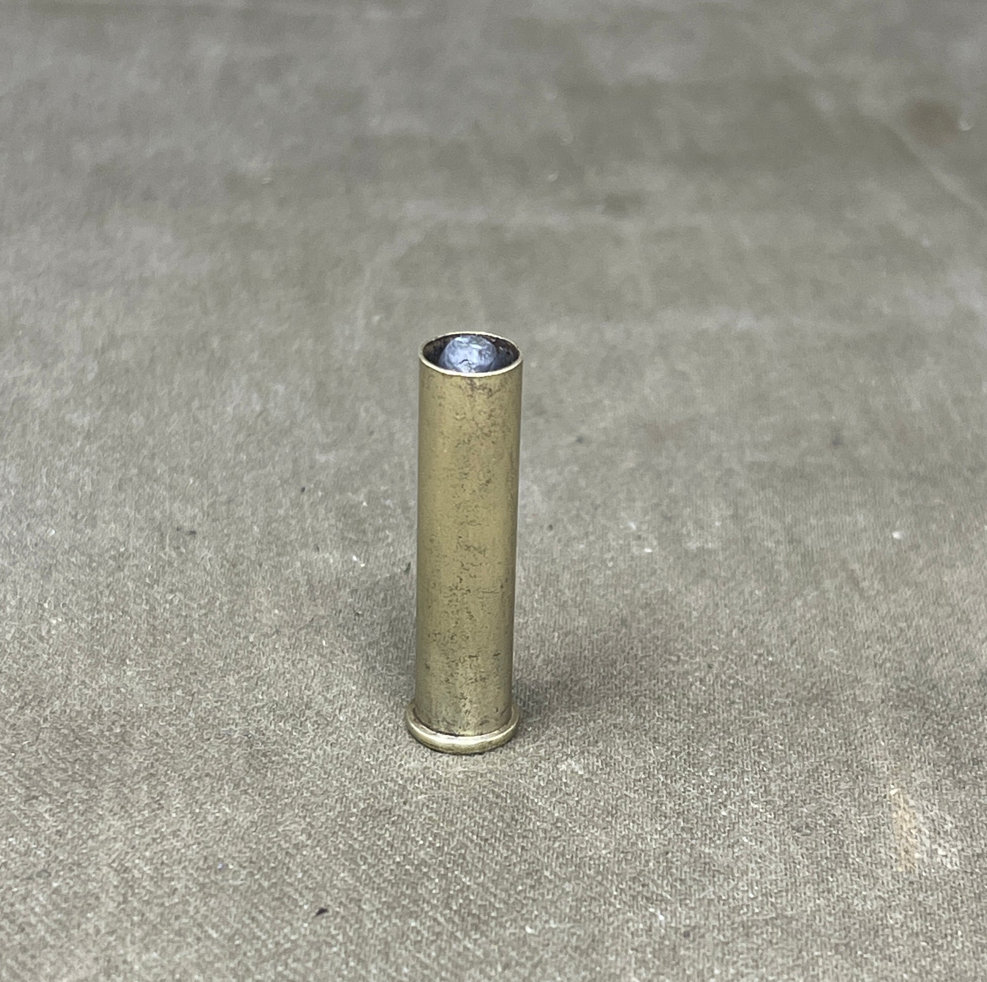 Metallic cylindrical object on a gray concrete surface