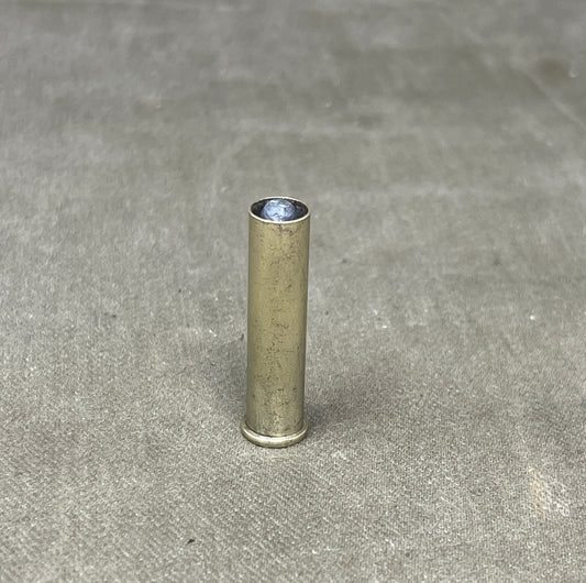 Metallic cylindrical object on a gray concrete surface
