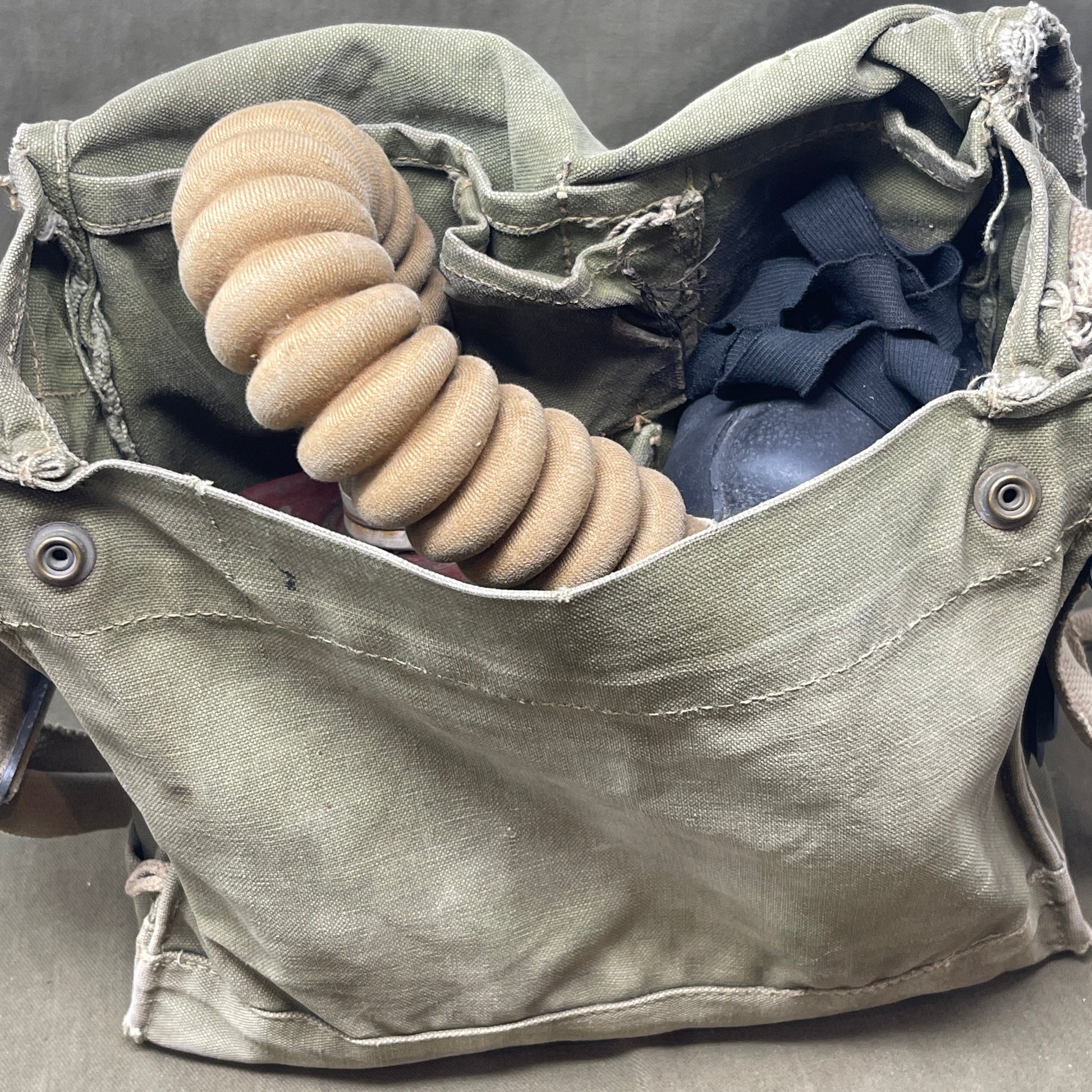 The British WW2 Respirator, Anti-Gas, General Service, Mk V, and Haversack, Mk VI provided essential protection against chemical warfare. The Mk V respirator featured a full-face rubber mask and filter canister, while the Mk VI canvas haversack ensured easy portability and access. Both were crucial for soldier safety during gas attacks