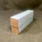 Rectangular cardboard box with a white top and brown bottom on a textured brown surface