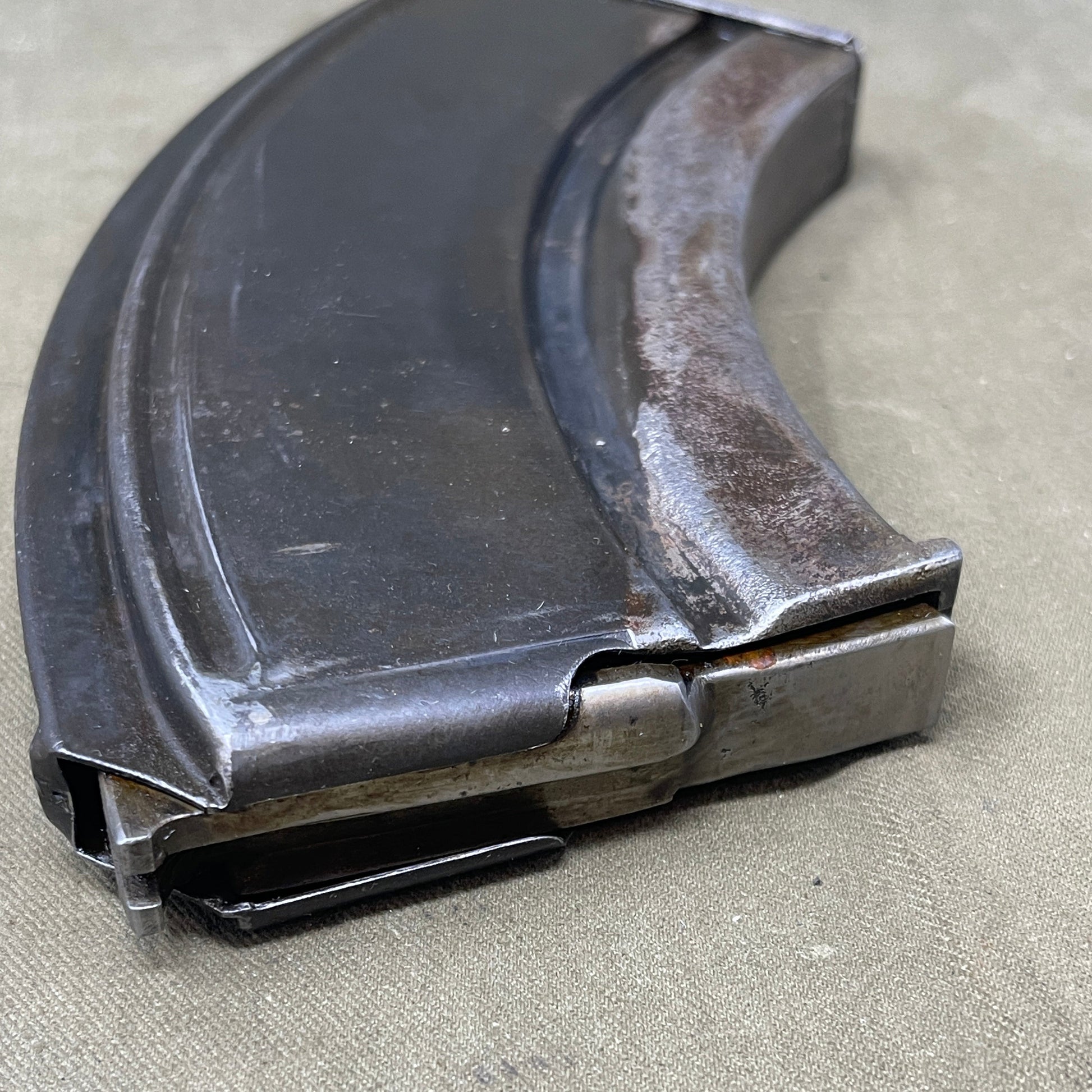 The Bren Gun magazine, iconic for its curved, box-like design, holds 30 rounds of .303 British ammo. Made from durable steel, it ensures reliable feeding and quick top-loading, crucial for mid-20th-century warfare. Renowned for its robustness and historical significance, it's prized by collectors and reenactors