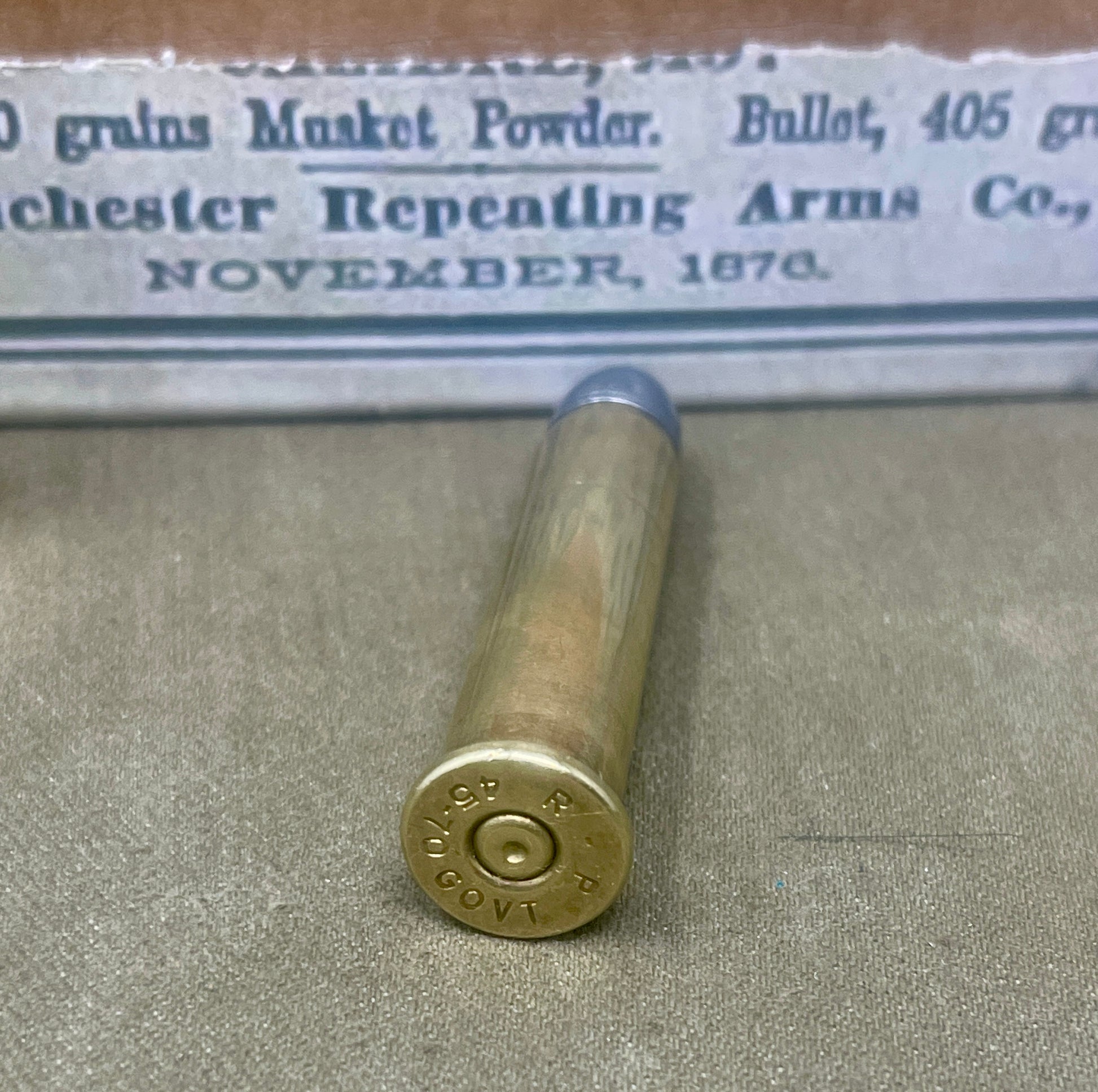 Vintage brass cartridge with a label in the background