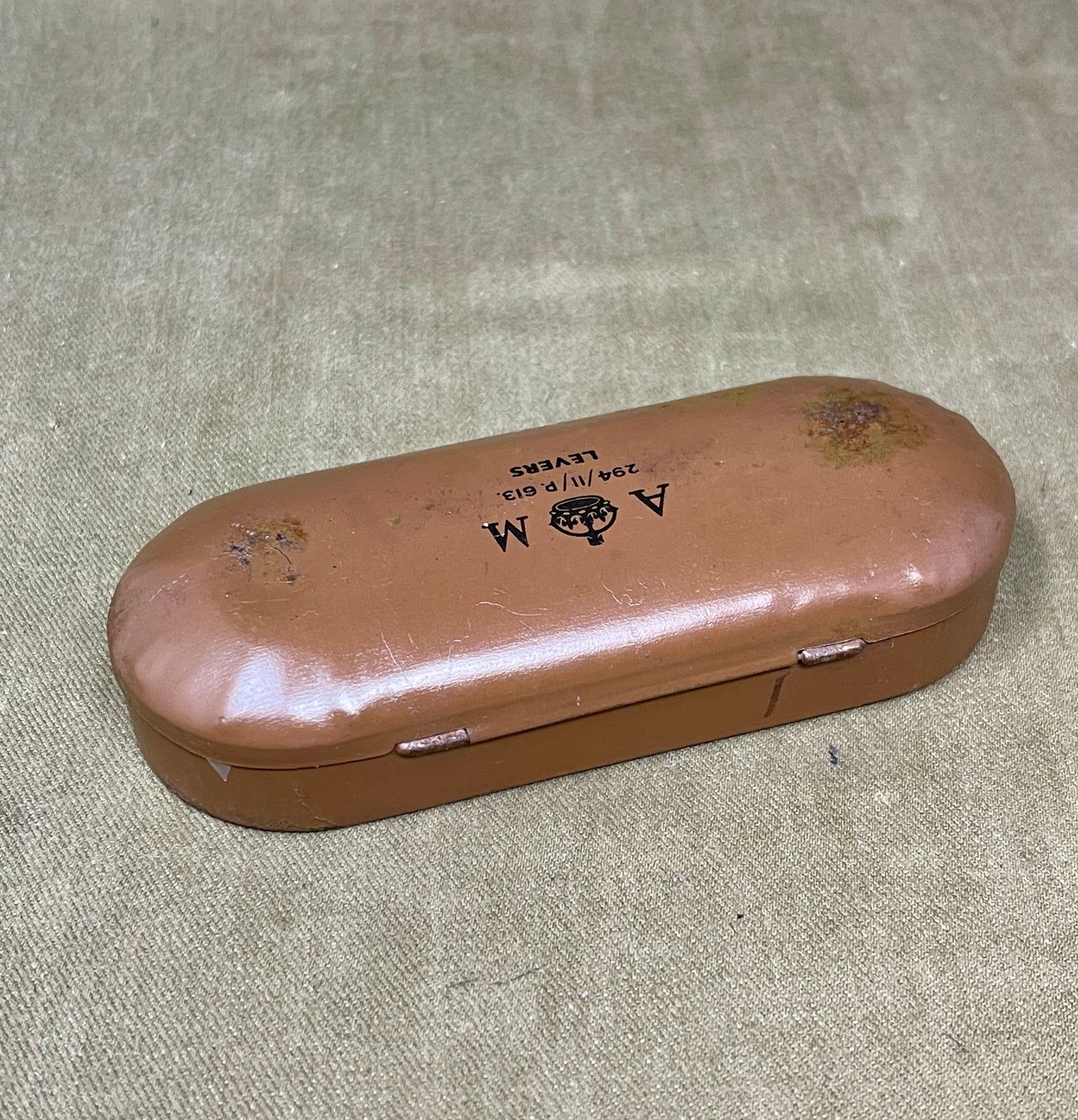 Brown eyeglass case with visible wear on a textured surface