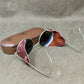 Vintage sunglasses with brown leather case on a textured surface