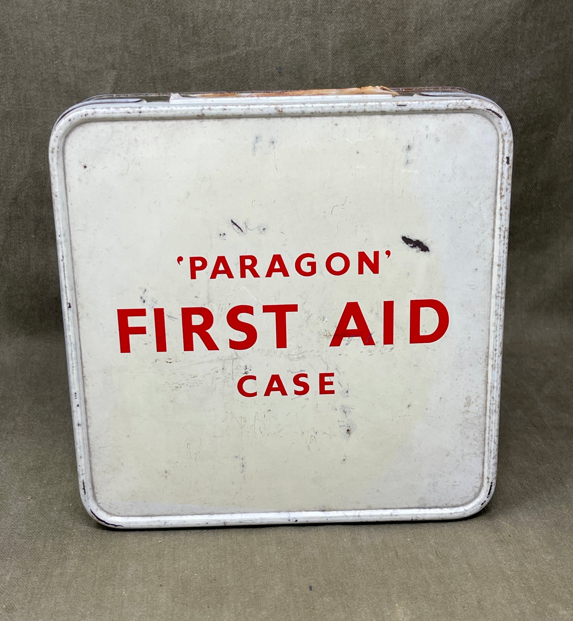 Vintage 'Paragon' first aid case with red text on a gray background